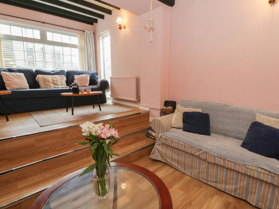 A living room with two sofas and a flower vase at 1 Alpha Cottages in Tenby