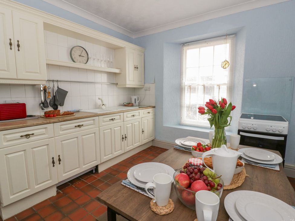 A kitchen with a table set for dining at 1 Alpha Cottages in Tenby