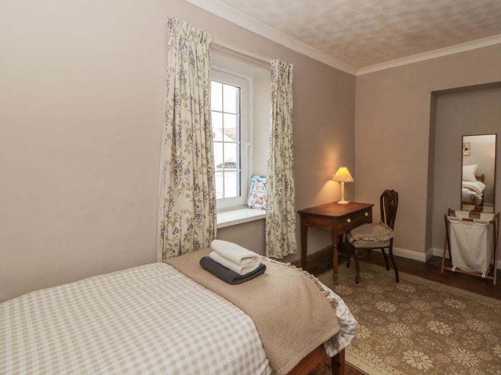 A bedroom with a bed and desk at 1 Alpha Cottages in Tenby