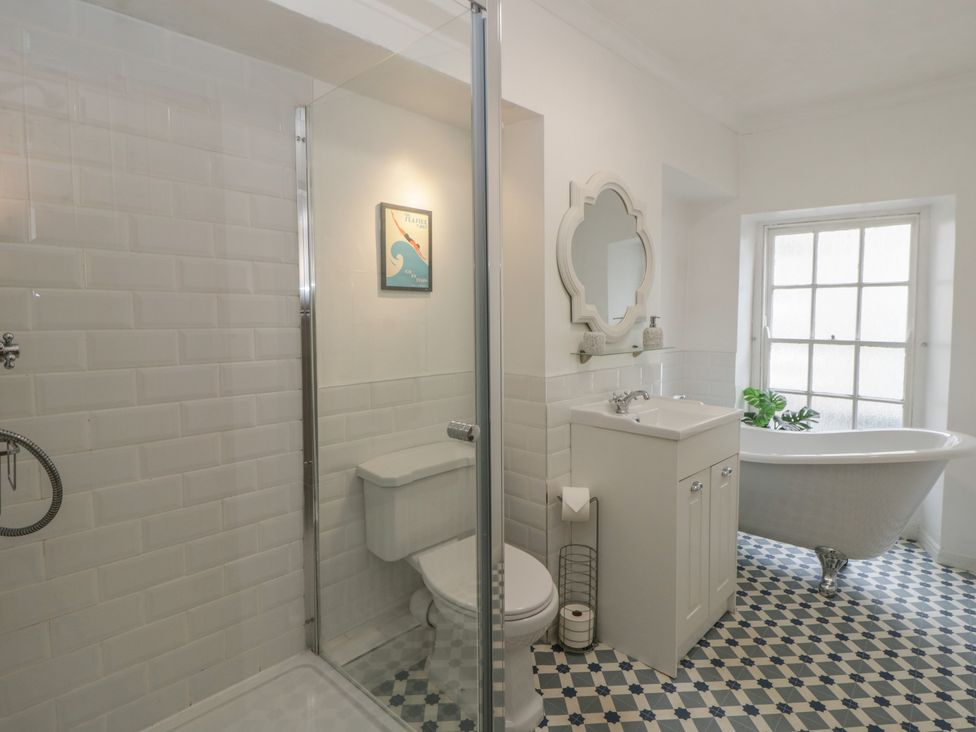 A bathroom with a shower, toilet, sink, and bathtub at 1 Alpha Cottages in Tenby
