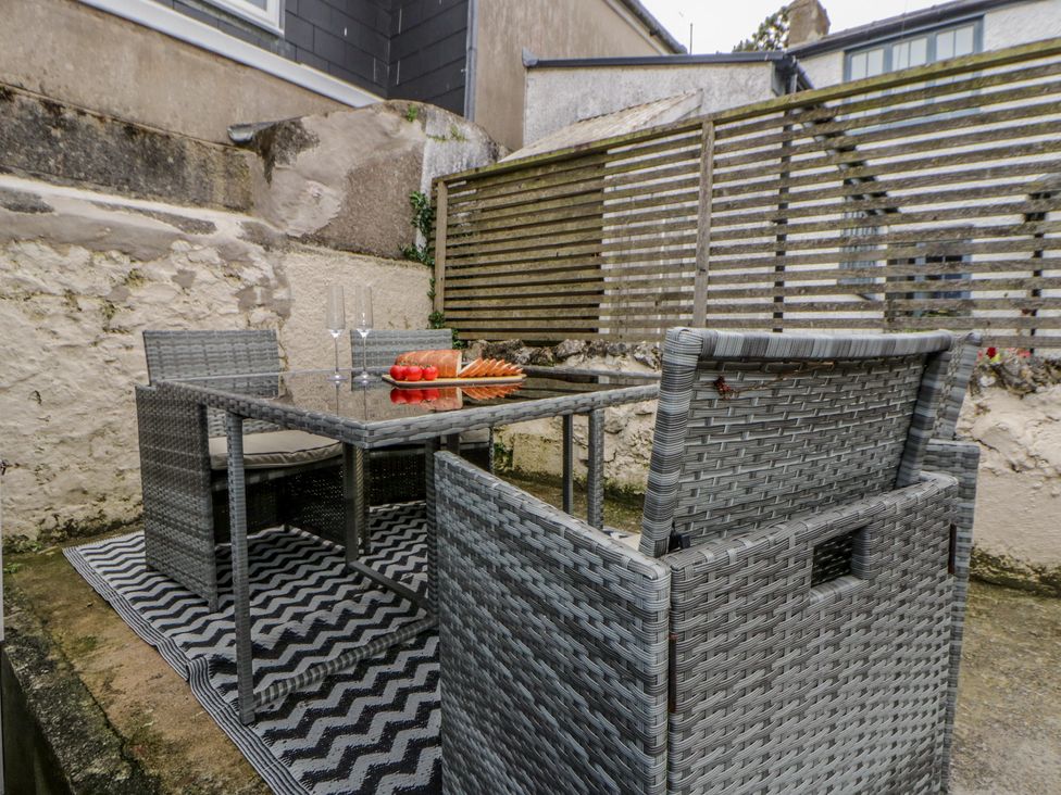 An outdoor seating area with a table and chairs at 1 Alpha Cottages in Tenby