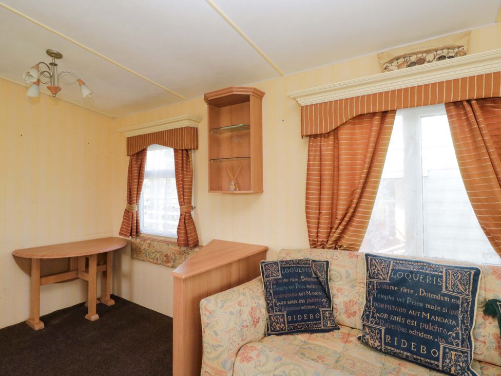 A living room with a table and sofa at Bengrove Wood Lodge in Shepton Mallet