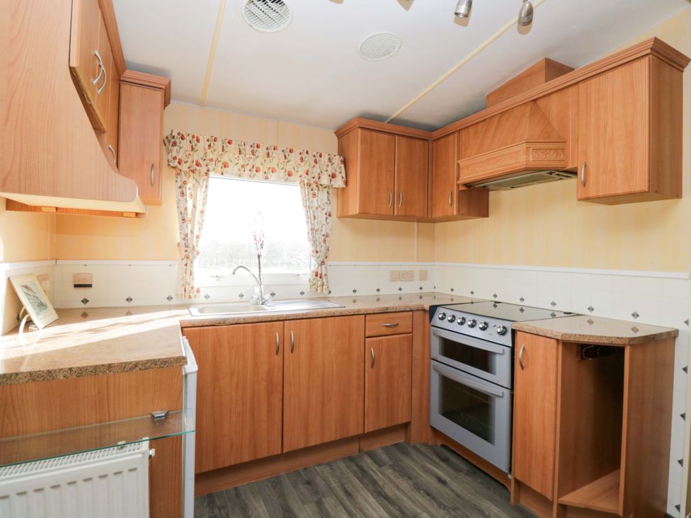 A kitchen with a sink and oven at Bengrove Wood Lodge in Shepton Mallet