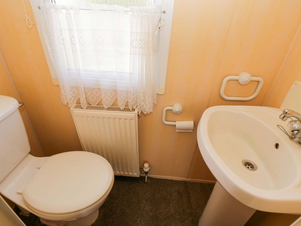 A bathroom with a toilet and sink at Bengrove Wood Lodge in Shepton Mallet