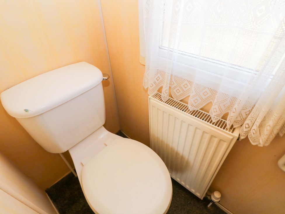 A bathroom with a toilet and a radiator at Bengrove Wood Lodge Shepton Mallet