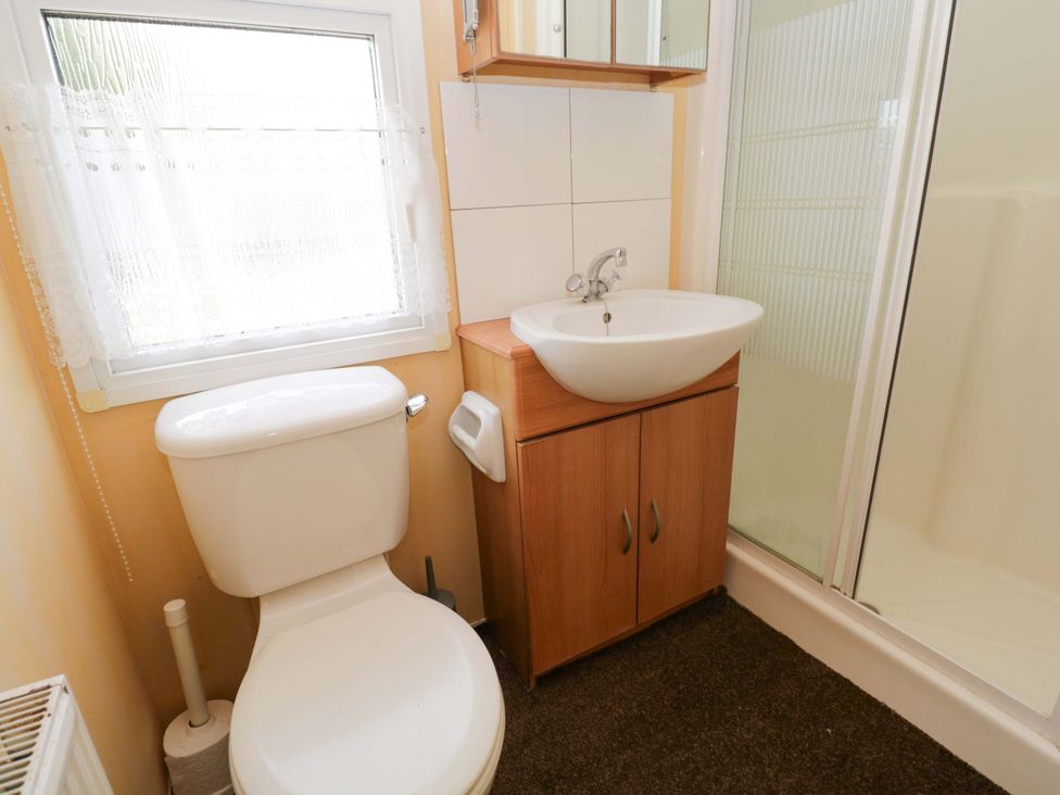 A bathroom with a toilet, sink, and shower at Bengrove Wood Lodge in Shepton Mallet