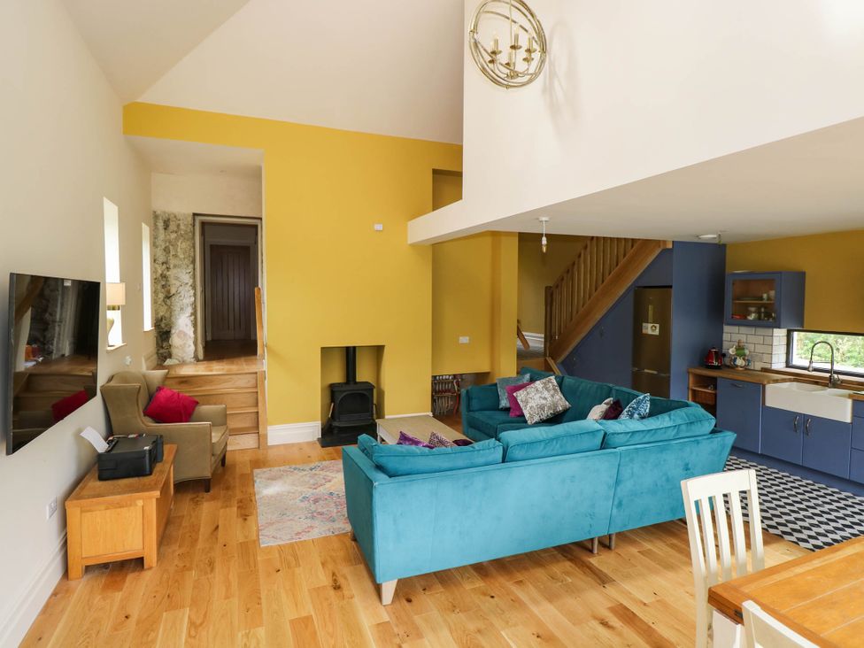 A living room with a sofa and staircase at The Cottage in Leenane, County Galway