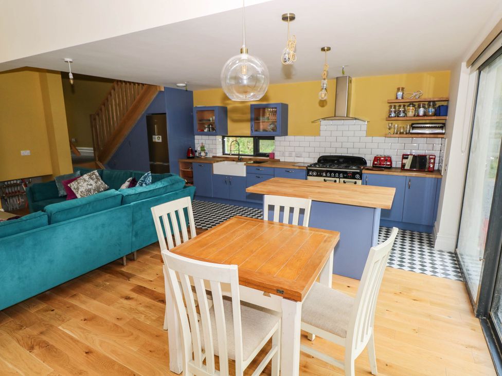 A kitchen with a dining table and sofa at The Cottage in Leenane, County Galway