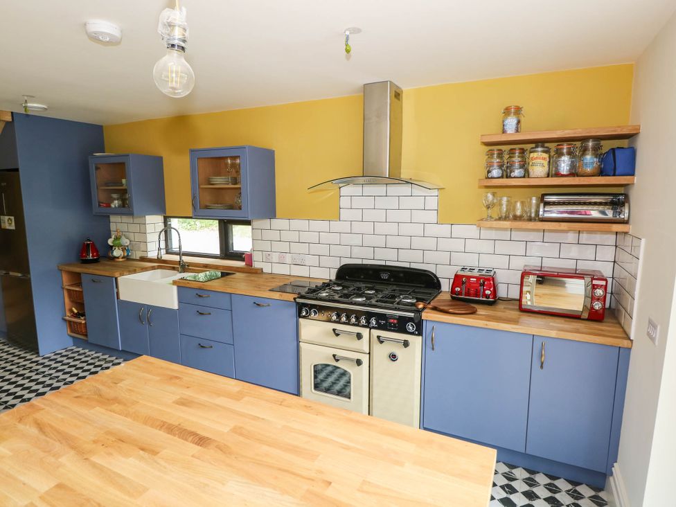 A kitchen with a stove, sink, and cupboards at The Cottage in Leenane, County Galway
