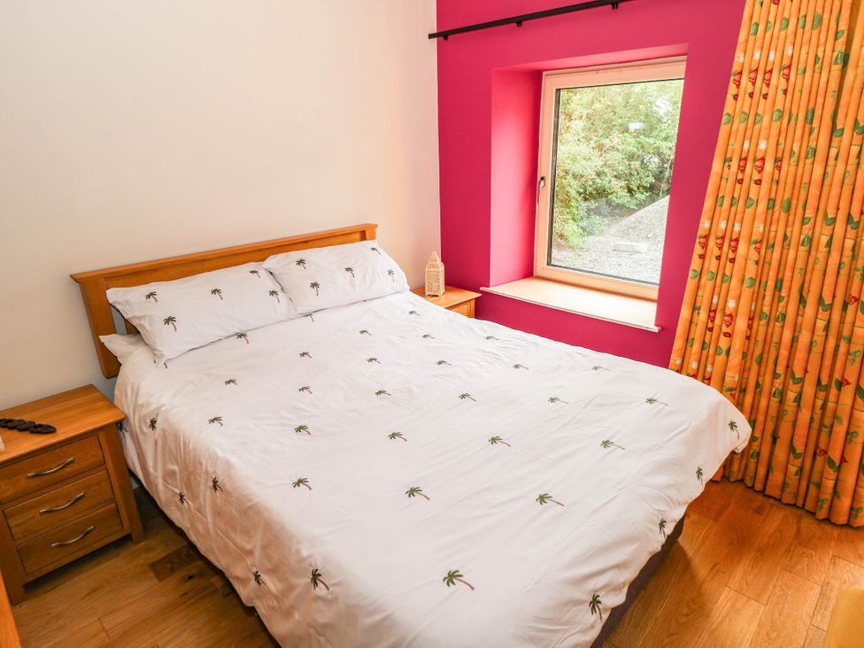 A bedroom with a bed and window at The Cottage in Leenane, County Galway