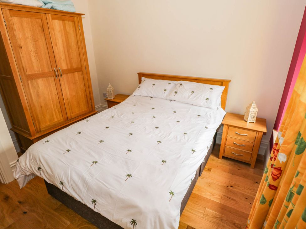 A bedroom with a bed and wardrobe at The Cottage in Leenane, County Galway