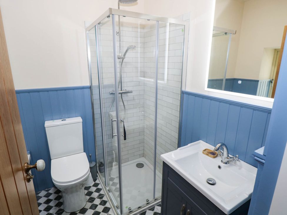A bathroom with a shower, toilet, and wash basin at The Cottage in Leenane, County Galway