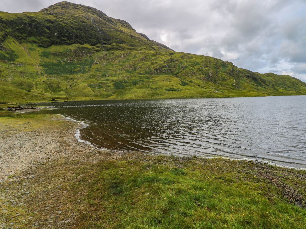 A lake surrounded by green hills at The Cottage in Leenane, County Galway