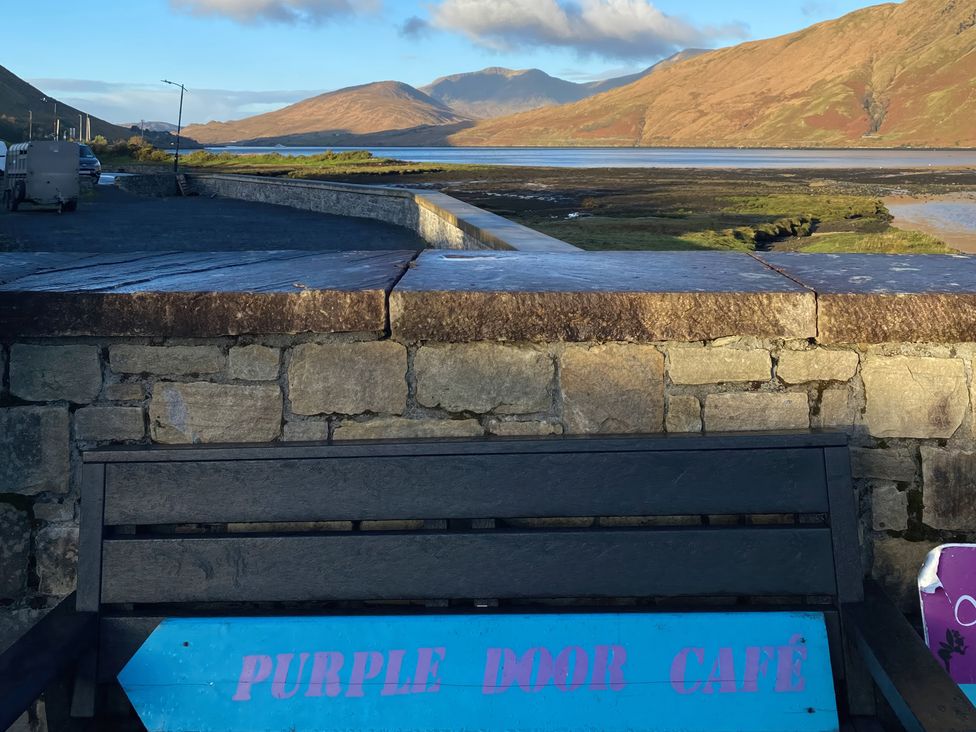 A bench with a sign by the water at The Cottage in Leenane, County Galway