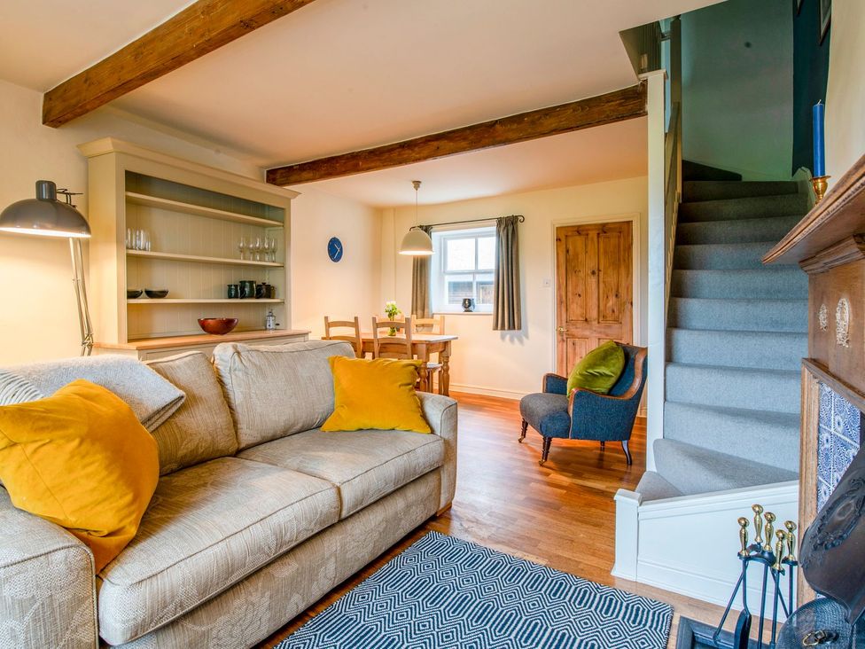 A living room with sofa and dining area at Beacon Cottage Ilkley