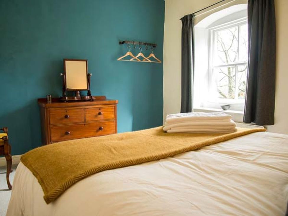 A bedroom with a bed and a dresser at Beacon Cottage in Ilkley