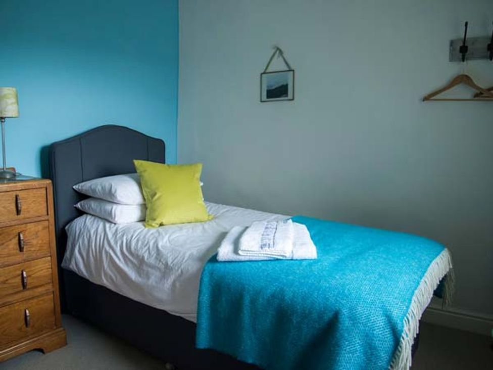 A bedroom with a single bed and bedside table at Beacon Cottage in Ilkley