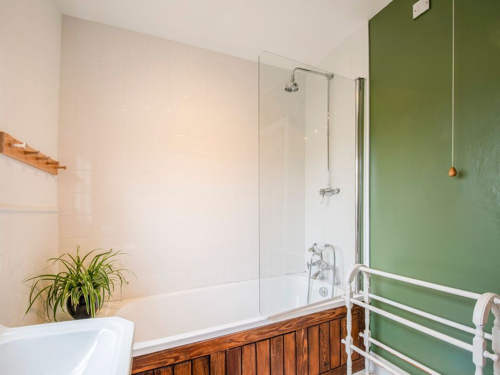 A bathroom with a bathtub and shower at Beacon Cottage in Ilkley