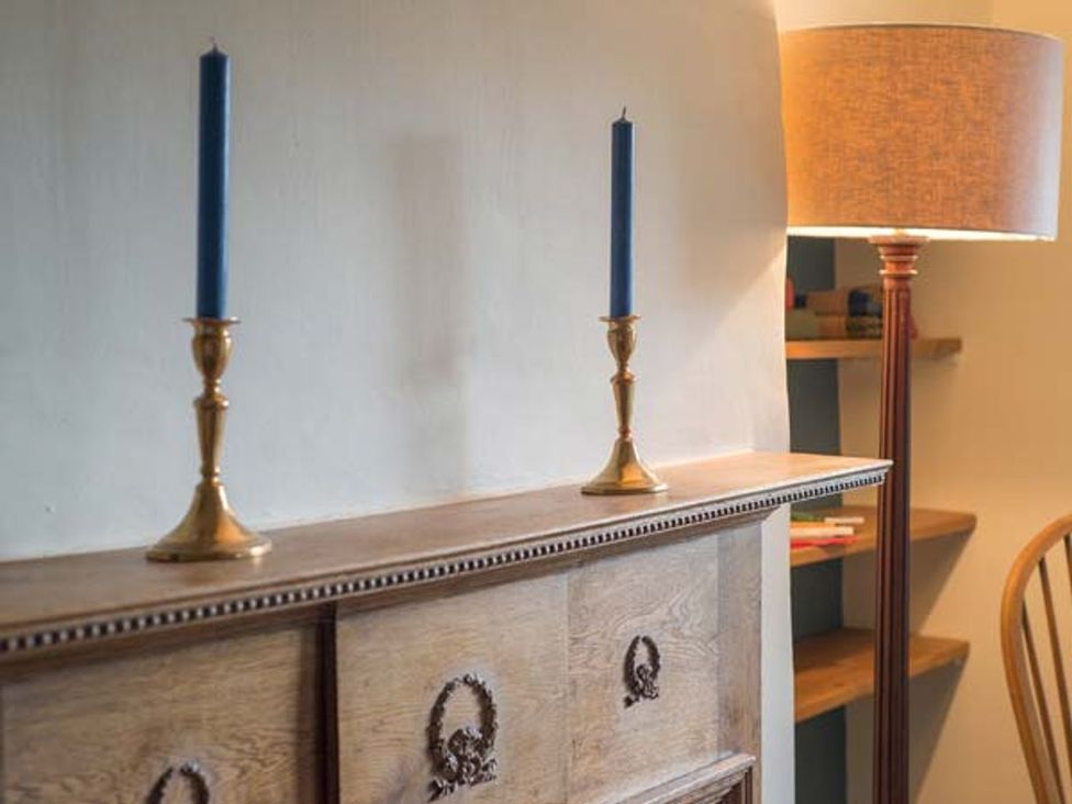A living room with candlesticks and a table lamp at Beacon Cottage in Ilkley