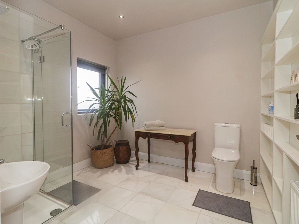 A bathroom with a shower, toilet, and a table at Hanowen House, Dungloe, County Donegal