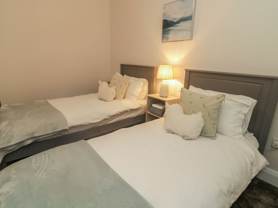 A bedroom with two single beds and a lamp on a nightstand at Hanowen House, Dungloe, County Donegal