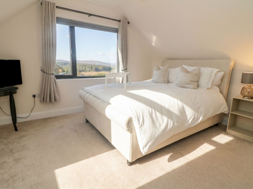 A bedroom with a bed and television at Hanowen House, Dungloe, County Donegal