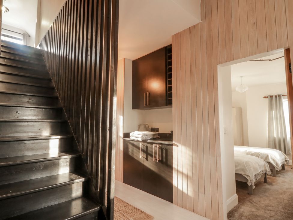 A hallway with stairs and a storage cabinet at Hanowen House in Dungloe, County Donegal