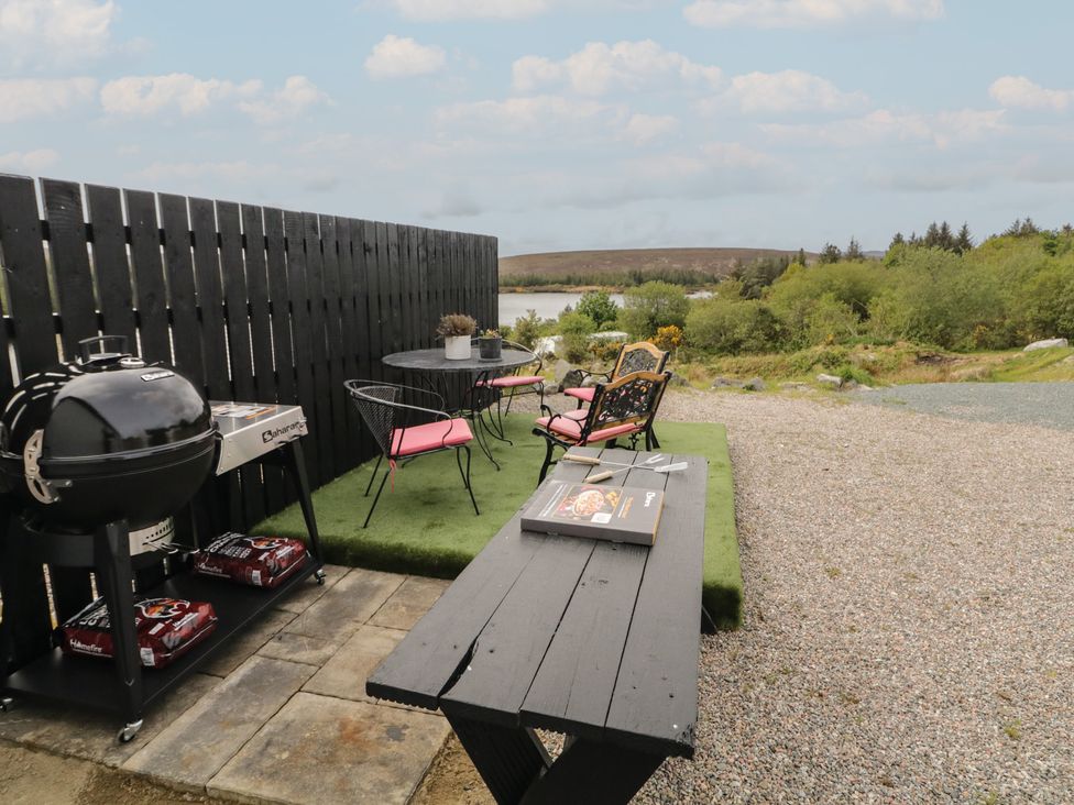 An outdoor dining area with grill and chairs at Hanowen House Dungloe, County Donegal