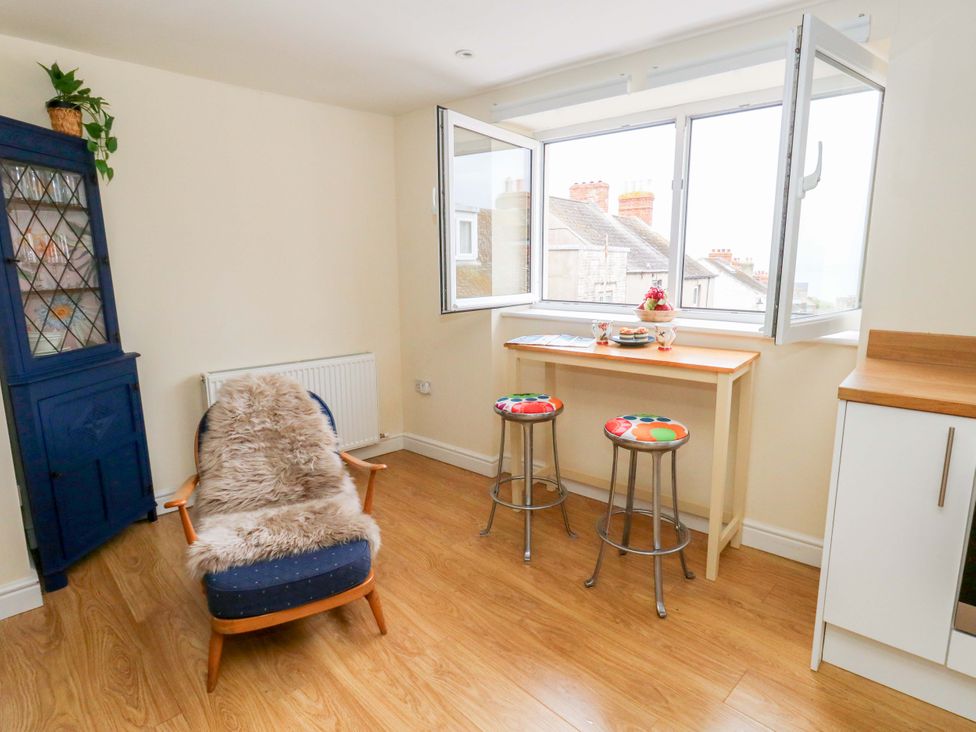 A kitchen with stools and a table near an open window at Flat 3 