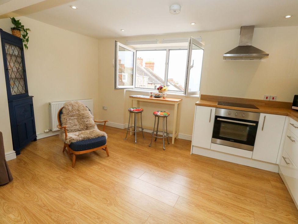 A kitchen with stools and an oven at Flat 3