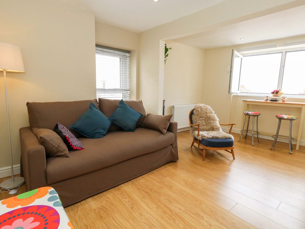 A living room with a sofa and a table at Flat 3