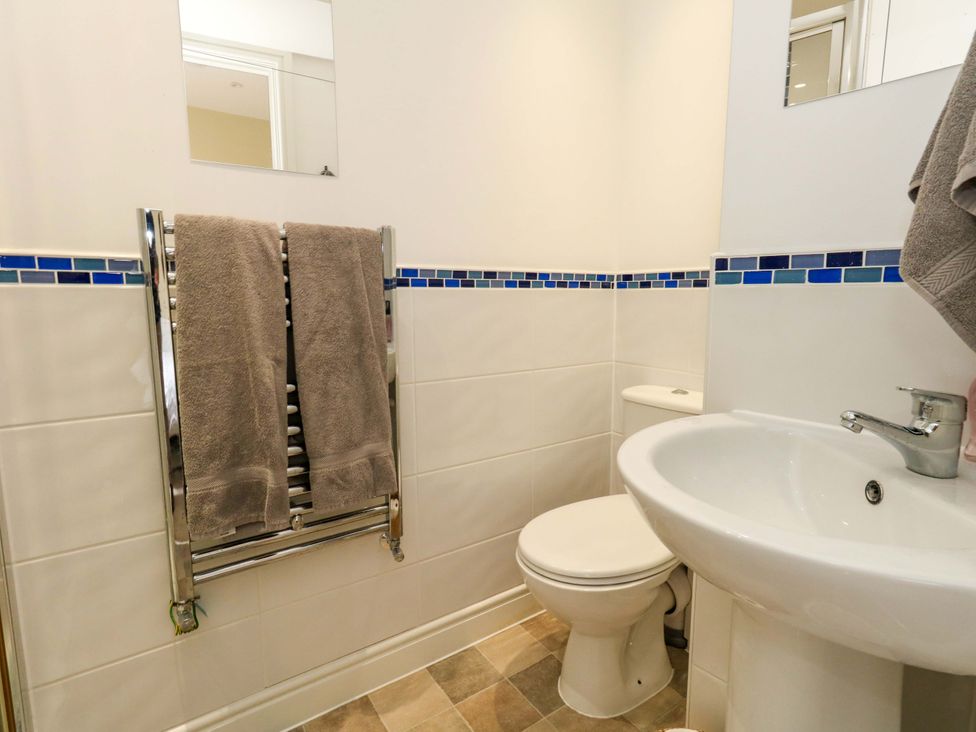 A bathroom with a toilet, sink, and towel rail at Flat 3