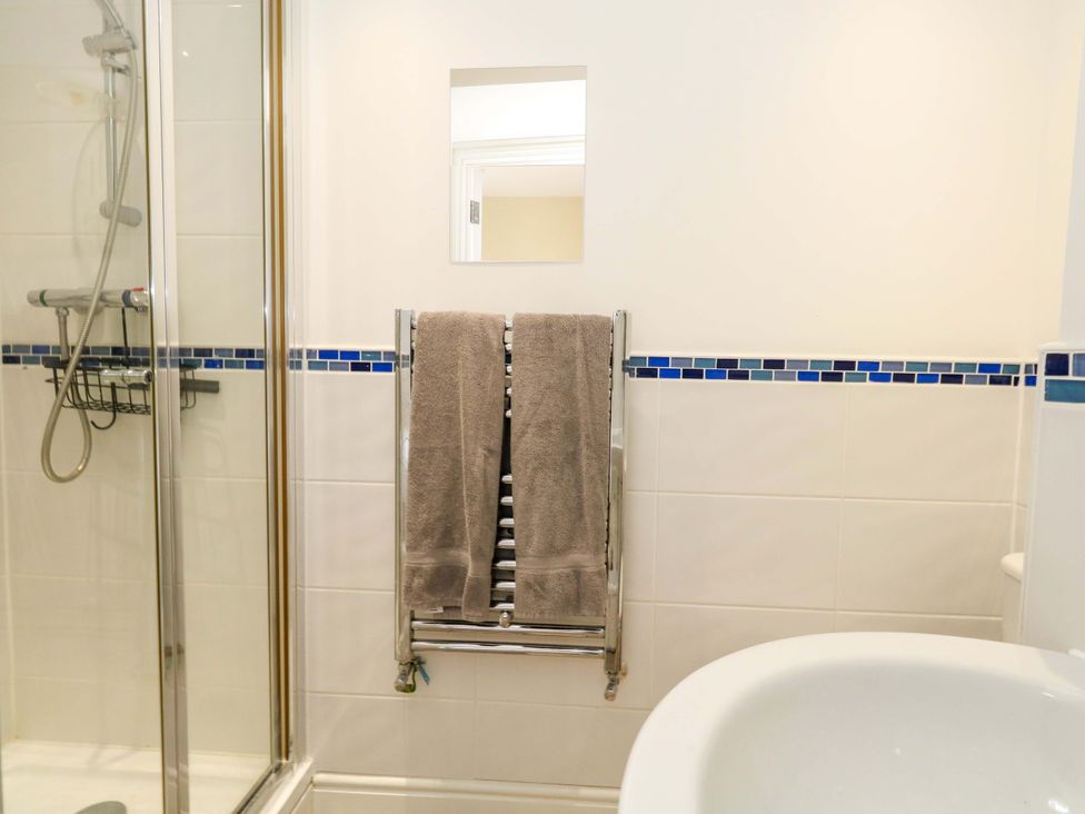A bathroom with a shower and towel rack at Flat 3 