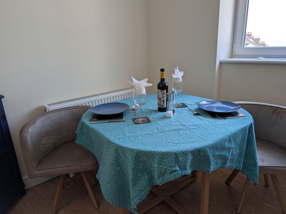 A dining room with a table set for two with wine and cutlery at Flat 3 Fortuneswell