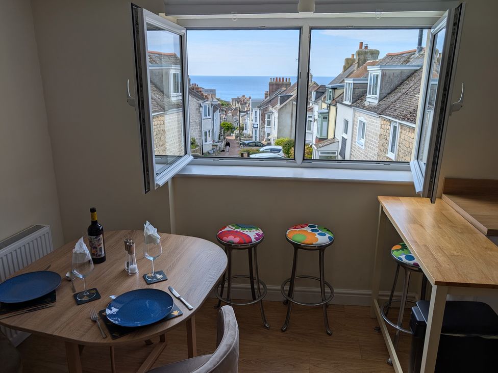 A dining room with a table and chairs overlooking a street at Flat 3 in Fortuneswell