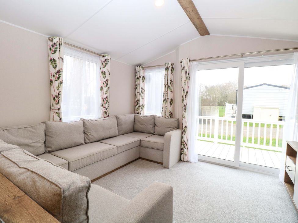 A living room with a sofa and windows at Caravan in Great Yarmouth