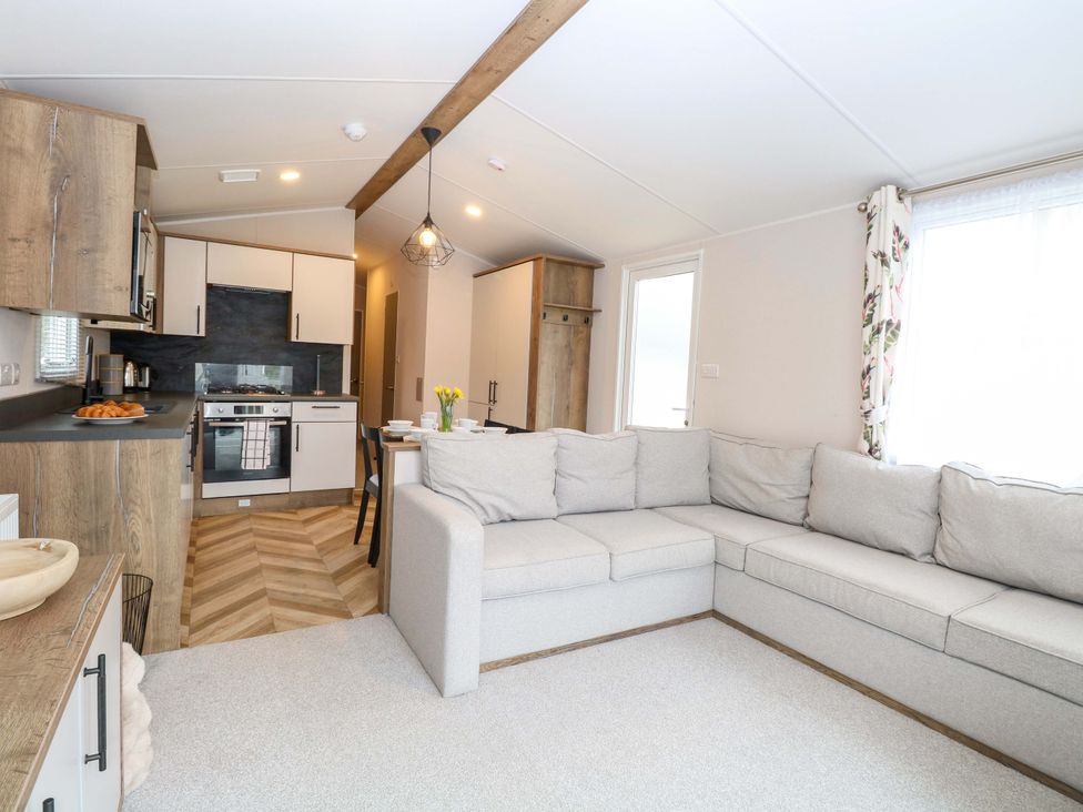 A living room with a sofa and kitchen area at Caravan in Great Yarmouth