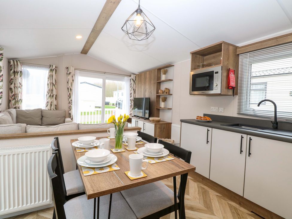A living room with a dining area and kitchen appliances at Caravan in Great Yarmouth