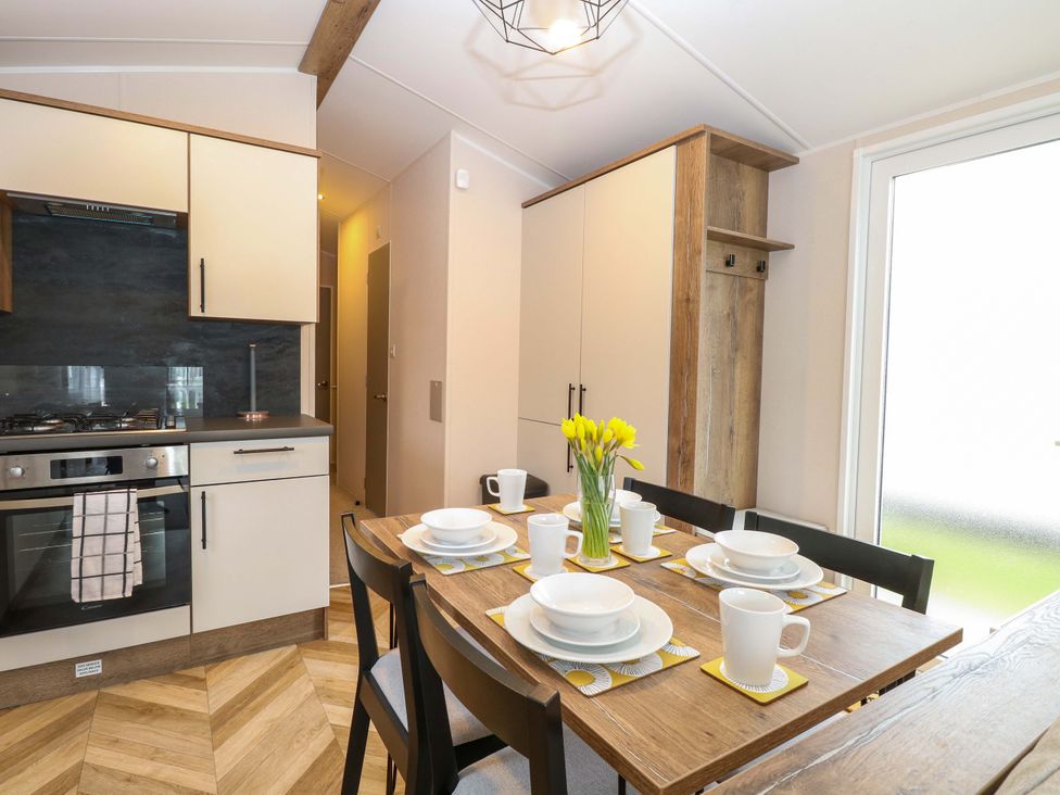 A kitchen with a dining table set for a meal at the Caravan in Great Yarmouth