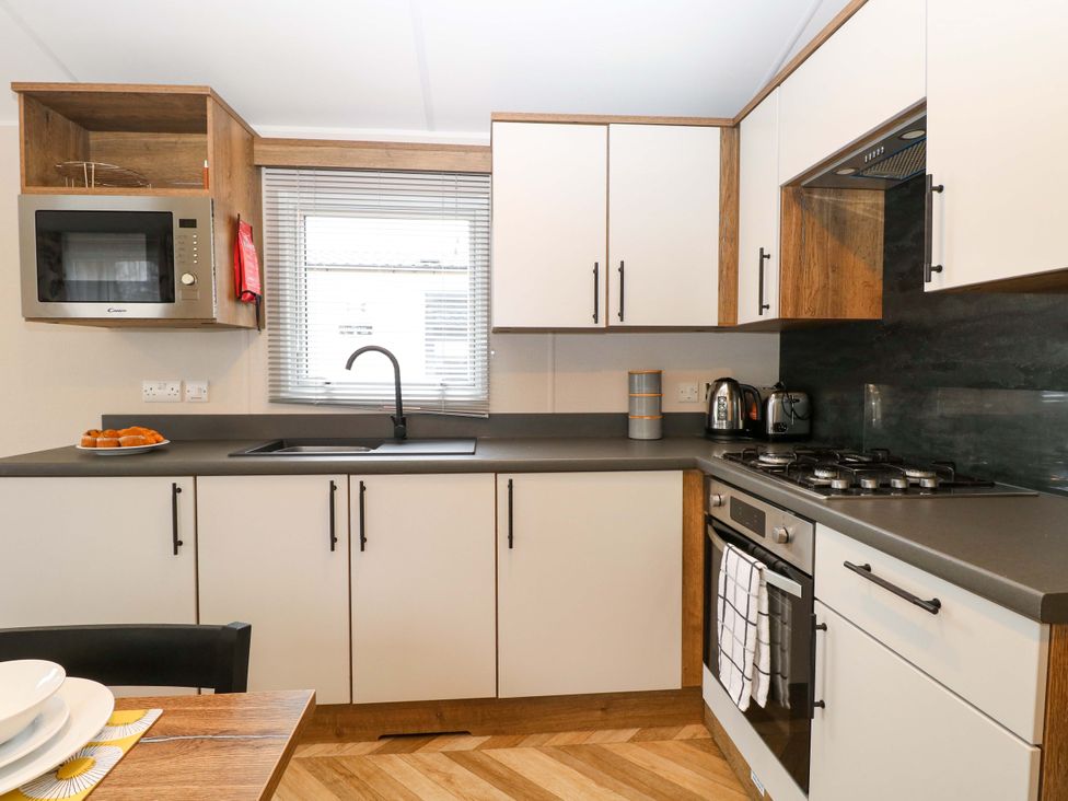 A kitchen with a microwave and sink at Caravan in Great Yarmouth