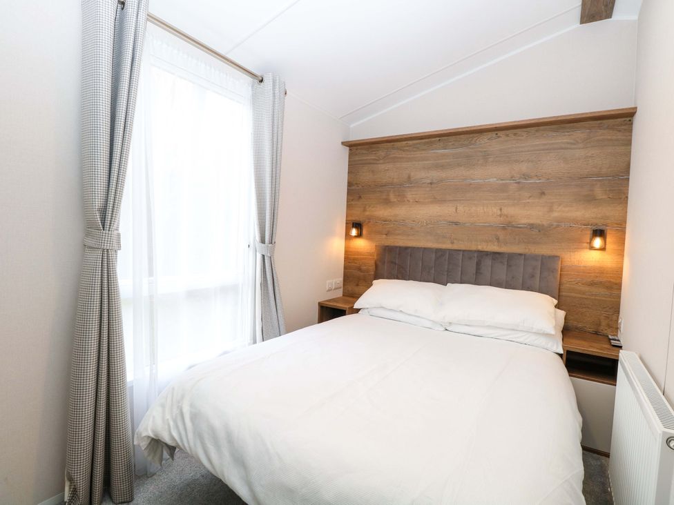 A bedroom with a bed and curtains at the Caravan in Great Yarmouth