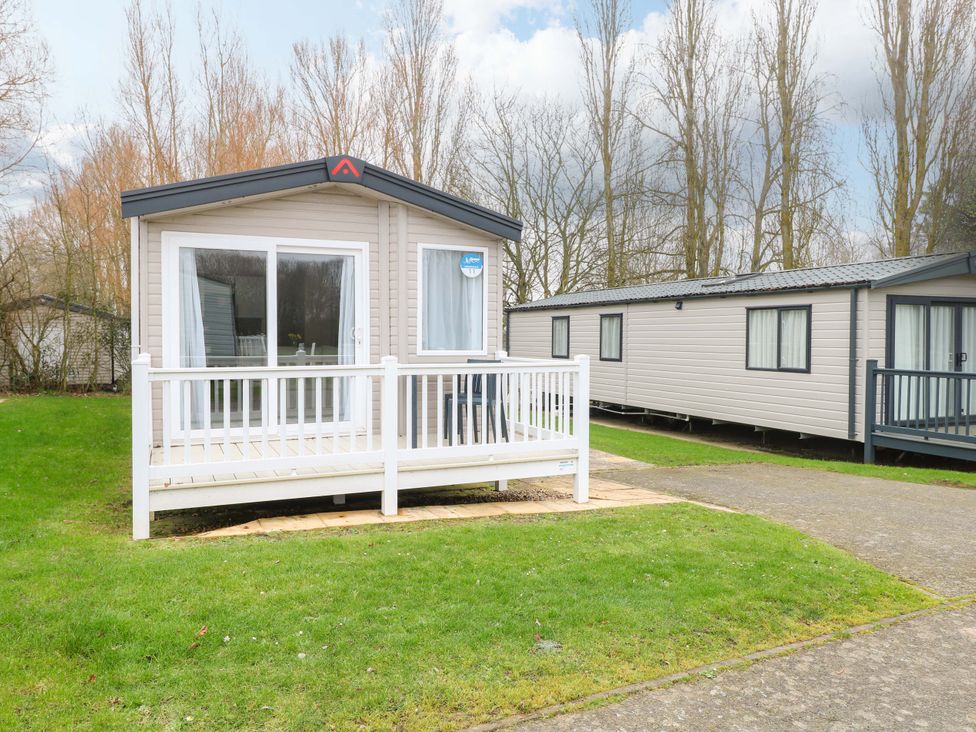 A caravan with a deck and grass area at Caravan in Great Yarmouth