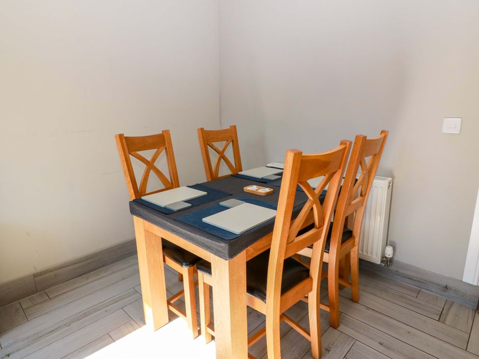 A dining room with a wooden table and chairs at Ledrishmore View in Alexandria