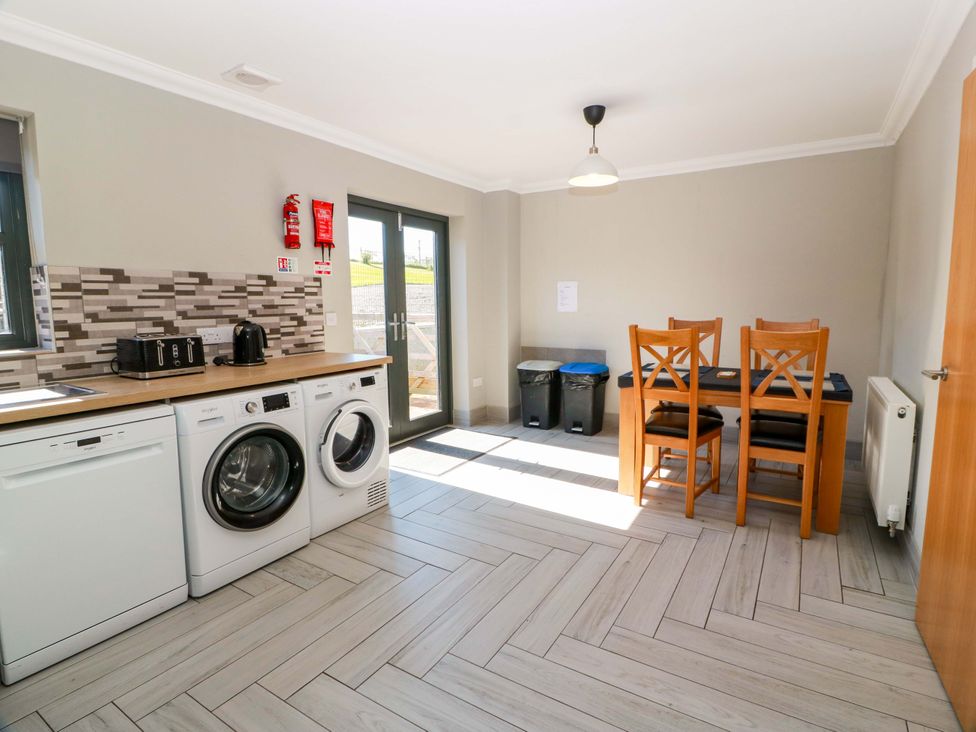 A kitchen with appliances and dining table at Ledrishmore View in Alexandria