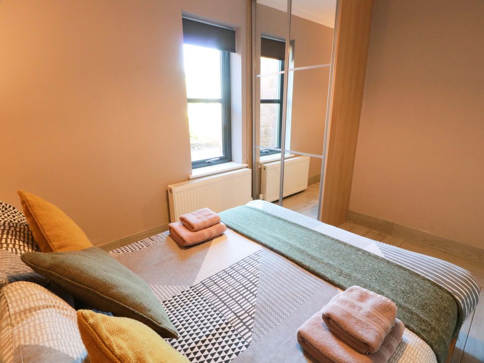 A bedroom with a bed and windows at Ledrishmore View in Alexandria