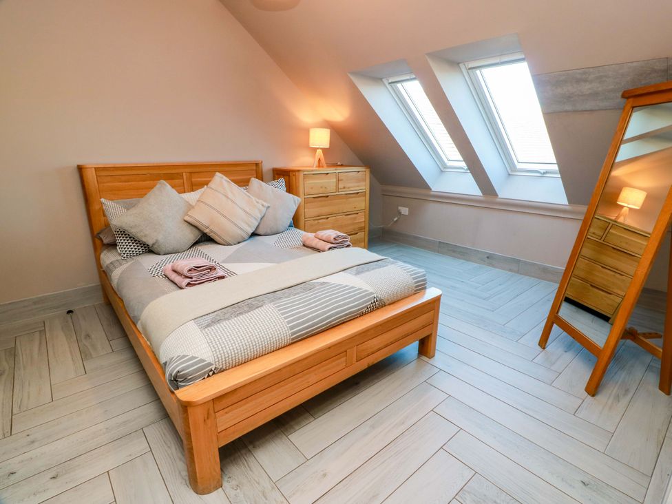 A bedroom with a bed, dresser, and mirror at Ledrishmore View in Alexandria