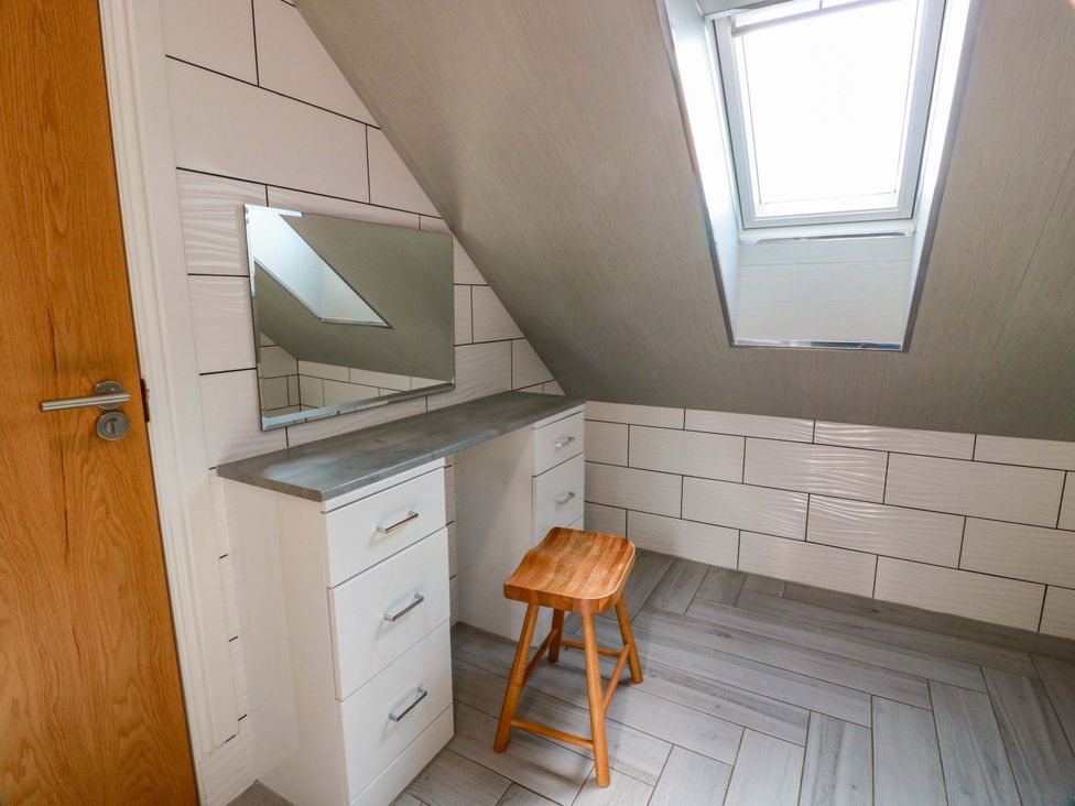 An attic room with a desk and mirror at Ledrishmore View in Alexandria