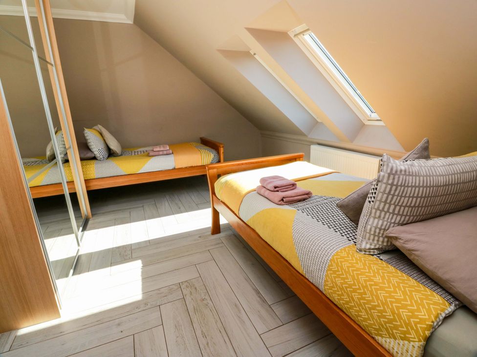 A bedroom with two beds and a mirror at Ledrishmore View in Alexandria