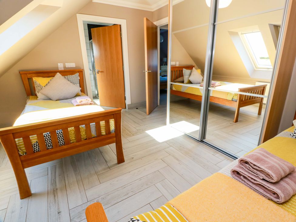 A bedroom with two beds and a mirror at Ledrishmore View in Alexandria