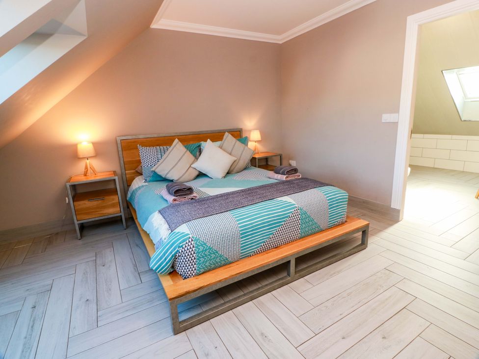 A bedroom with a bed, nightstand, and lamp at Ledrishmore View in Alexandria
